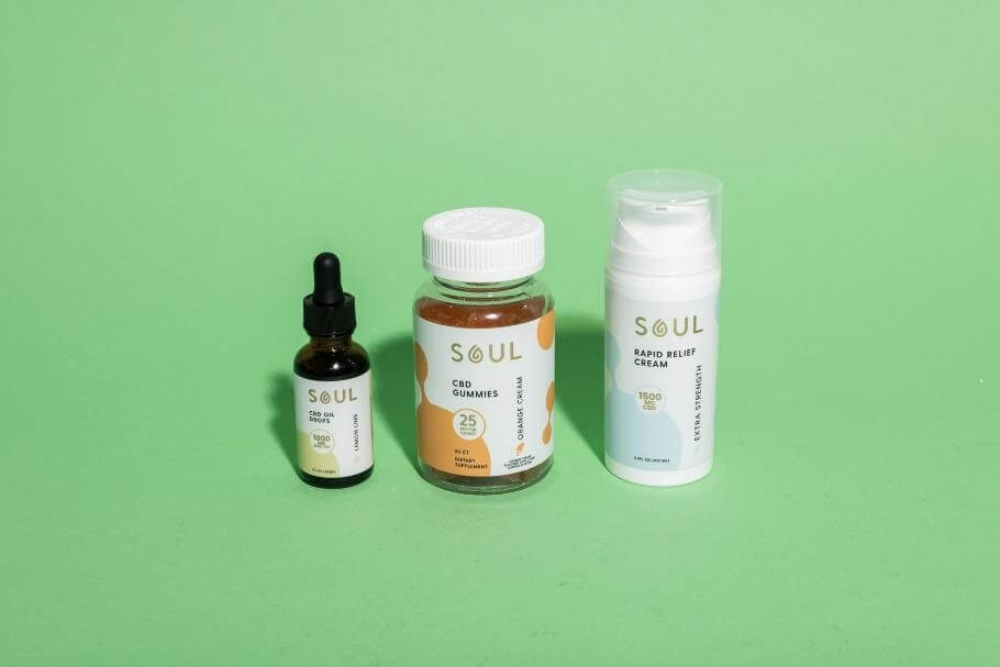 Front view of three Soul CBD products — tincture, jar of gummies, and rapid relief cream — on light green background