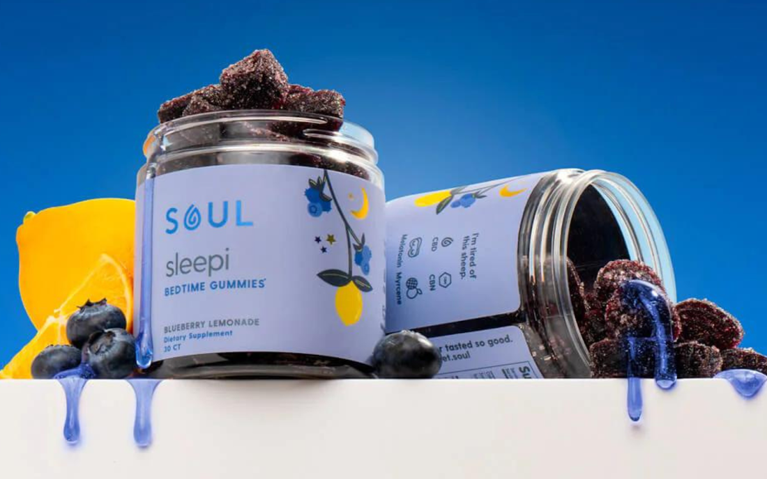Angled view of Soul Sleepi bedtime gummies jar spilling blueberry lemonade gummies against a bright blue background