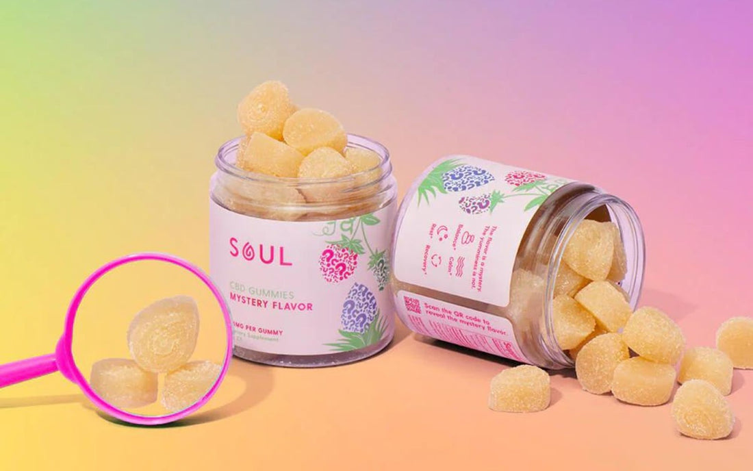 Front view of Soul CBD gummies jar showing Mystery Flavor label and sugar-coated yellow gummies on a pink-purple gradient background