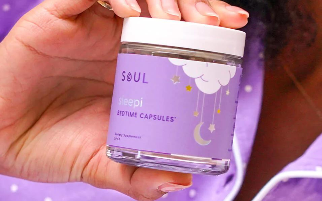 Close-up of Sleepi bedtime capsules jar by Soul held in hand showing purple label with cloud, stars, and moon graphics