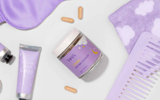 Angled overhead view of Soul Sleep bedtime capsules jar showing purple label and three capsules on a white background with lavender sleep props