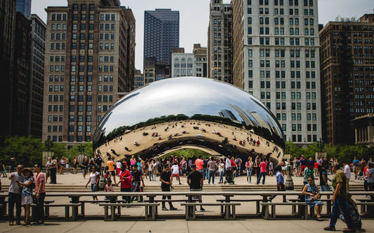 Cloud Gate reflecting the Chicago skyline with visitors gathered in the plaza