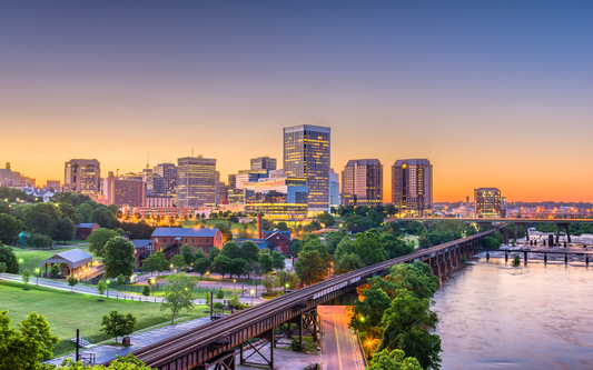 Virginia city skyline at sunset with river, bridges, and illuminated buildings