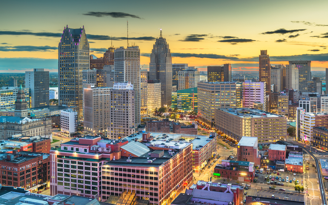 Detroit skyline at sunset with illuminated downtown skyscrapers and busy city streets