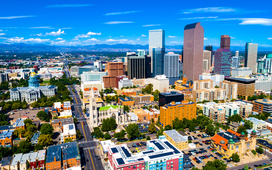 Aerial view of Denver skyline with the Colorado State Capitol and distant Rocky Mountains