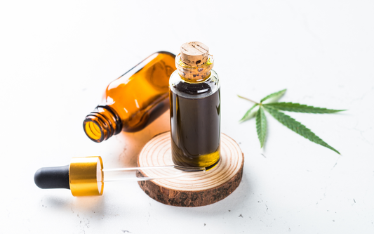 Two amber tincture bottles with a dropper and a cannabis leaf on a white surface representing CBN and CBG oils