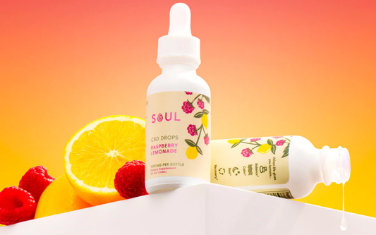 Soul Raspberry Lemonade CBD bottle with label and dripping dropper, orange and raspberries on gradient background