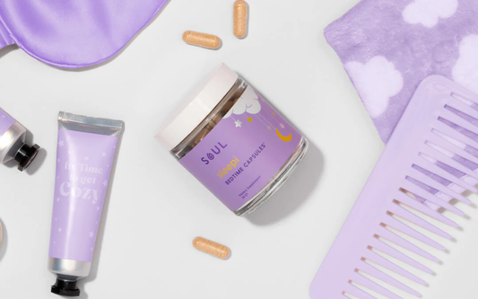Angled top-down view of Soul Sleepi bedtime capsules jar showing purple label and two capsules with lavender sleep accessories on white