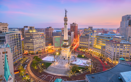 Soldiers and Sailors Monument at dusk with Indianapolis downtown skyline and car light trails