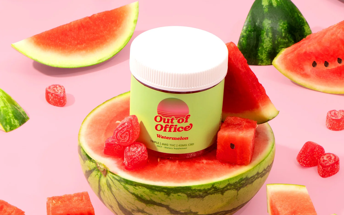 Front view of Out of Office Watermelon gummy jar showcasing bright green label and white lid inside a halved watermelon on a pink background