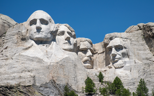Mount Rushmore National Memorial showing four presidential faces carved in granite against a clear blue sky