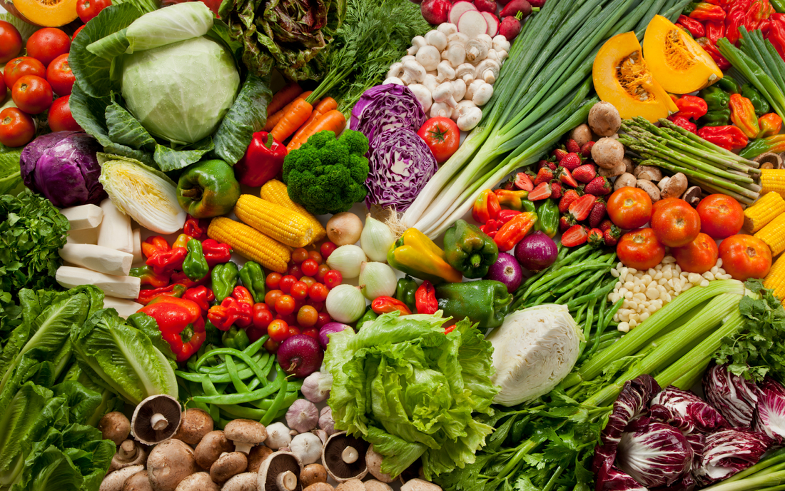 Assortment of colorful fresh fruits and vegetables arranged in a flat lay