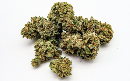 Close-up of cannabis buds showing dense green nugs with orange pistils and frosty trichomes on white background