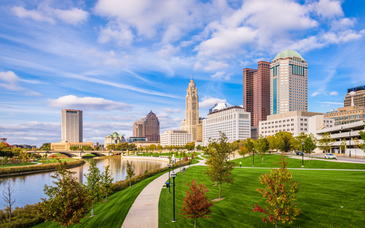 Columbus, Ohio skyline over the Scioto River with riverside park and winding walkway on a sunny day