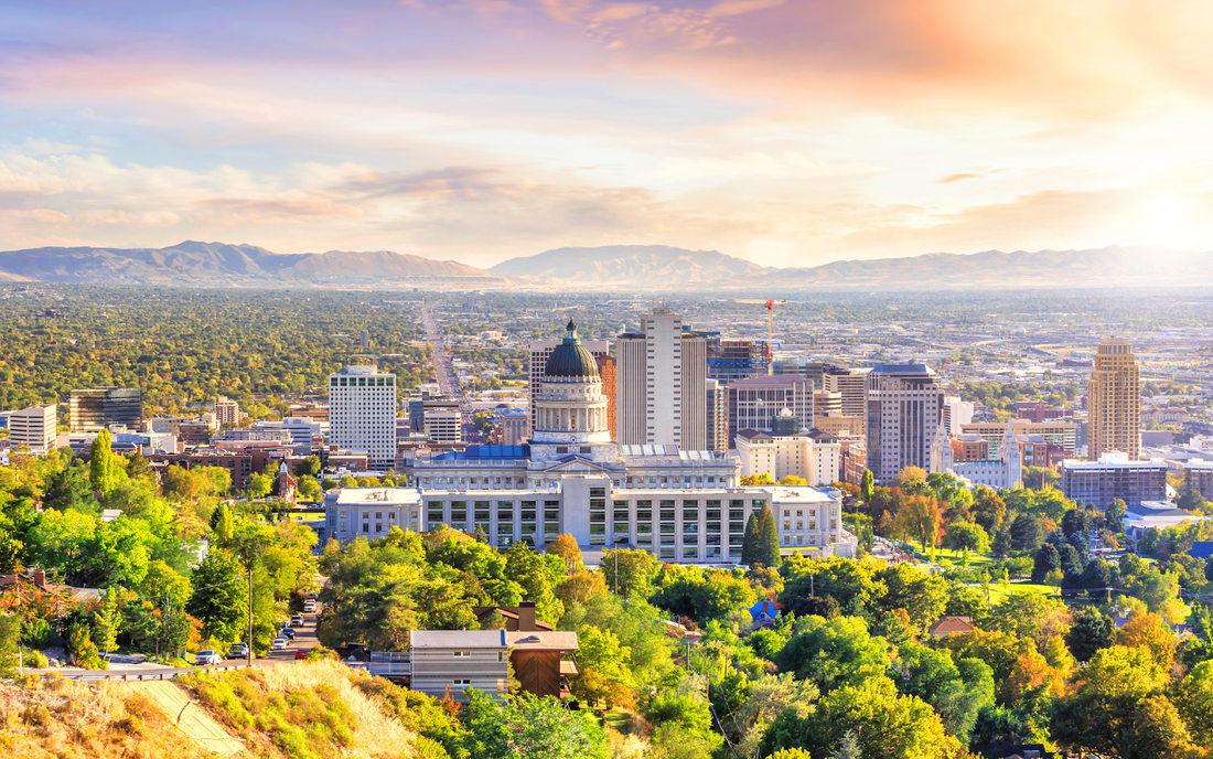 Salt Lake City skyline at sunrise with the Utah State Capitol building in the foreground and the Wasatch Mountains beyond