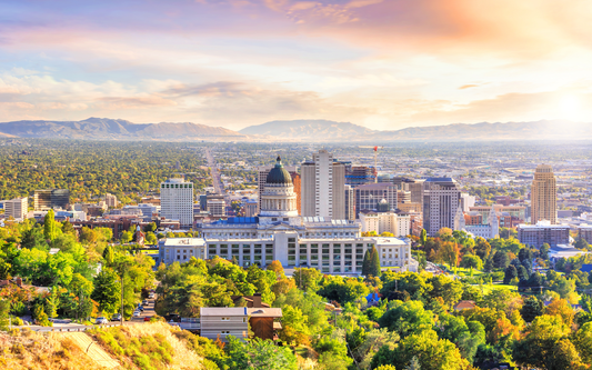 Salt Lake City skyline at sunrise with the Utah State Capitol building in the foreground and the Wasatch Mountains beyond