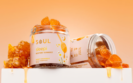 Front view of Soul Sleepi bedtime gummies jar showcasing honey chamomile gummy pieces spilling from an open jar with an orange gradient background