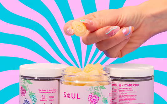 Hand holding a peach gummy above an open jar of Soul gummies against a pink-and-teal radiating background