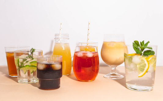 Assortment of alcohol-free mocktails and relaxing drinks on a table, garnished with citrus, mint, and ice