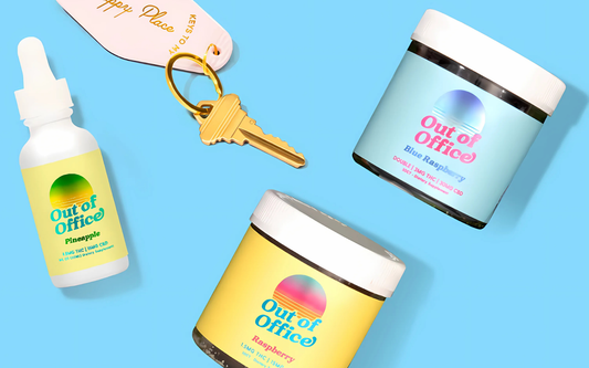 Flat lay of Out of Office jars and dropper bottle showing colorful sunrise logo and flavor labels (Pineapple, Raspberry, Blue Raspberry) on a blue background
