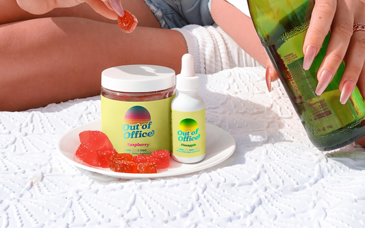 Front view of Out of Office raspberry gummy jar and pineapple tincture bottle showing labels and red gummies on a blanket