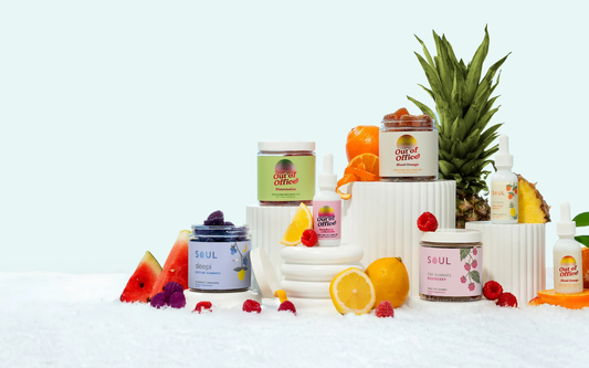 Front view of assorted Soul and Out of Office CBD gummies and tincture bottles with fruit props on a snowy white surface