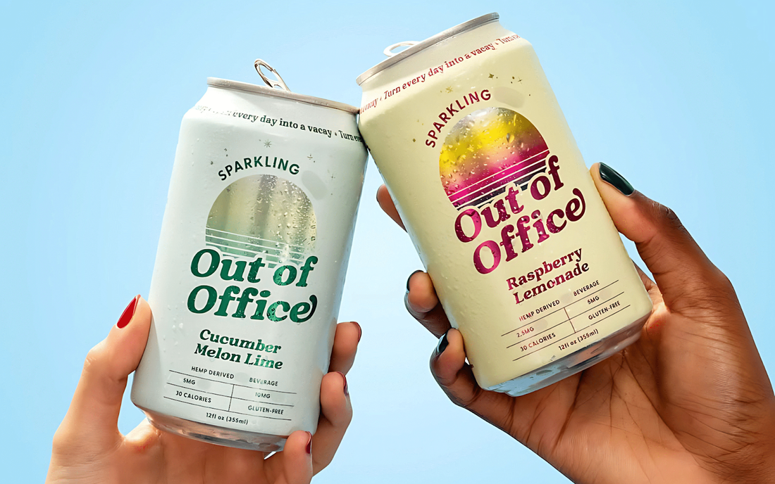 Two hands clinking Out of Office sparkling cans, cucumber melon lime and raspberry lemonade, on pale blue background
