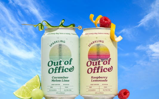 Front of two Out of Office sparkling cans, Cucumber Melon Lime and Raspberry Lemonade, with lime and raspberry on blue sky