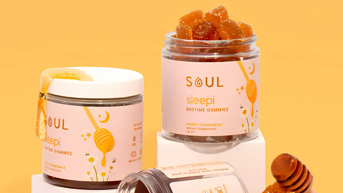 Front view of Soul Sleepi bedtime gummies jar with pink label, open lid and honey-colored gummies on yellow background