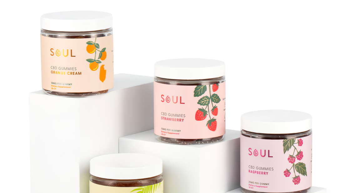 Front view of Soul CBD gummies jars in orange cream, strawberry, and raspberry flavors on white display pedestals