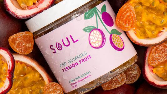 Angled close-up of Soul Passion Fruit CBD gummies jar labeled Passion Fruit 2 mg, with halved passion fruits and gummies