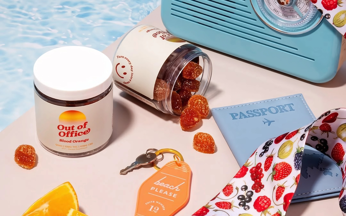 Angled top-down view of Out of Office Blood Orange gummy jar with sugar-coated gummies spilled on a pastel poolside flat lay