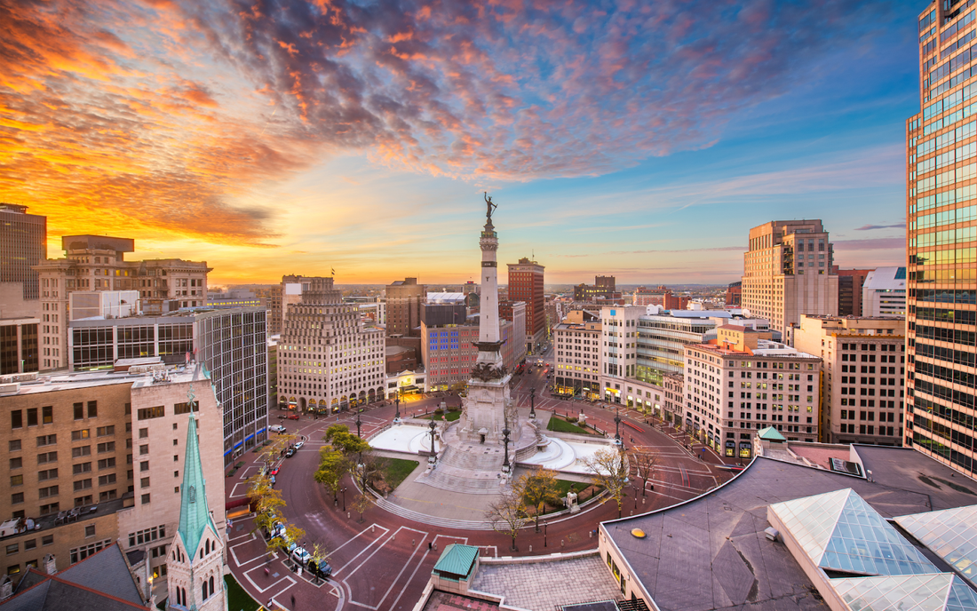 Soldiers and Sailors Monument at Monument Circle in downtown Indianapolis at sunrise with surrounding city buildings