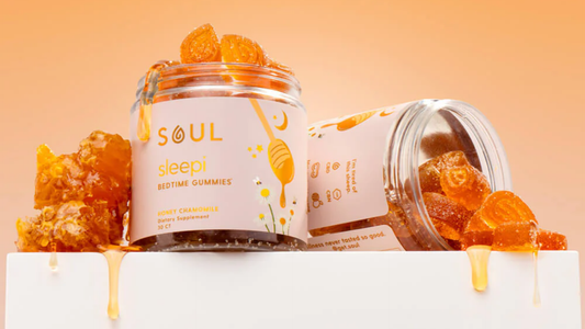 Angled front view of Sleepi gummies jar with honey-drizzled orange gummies and honeycomb on an orange background