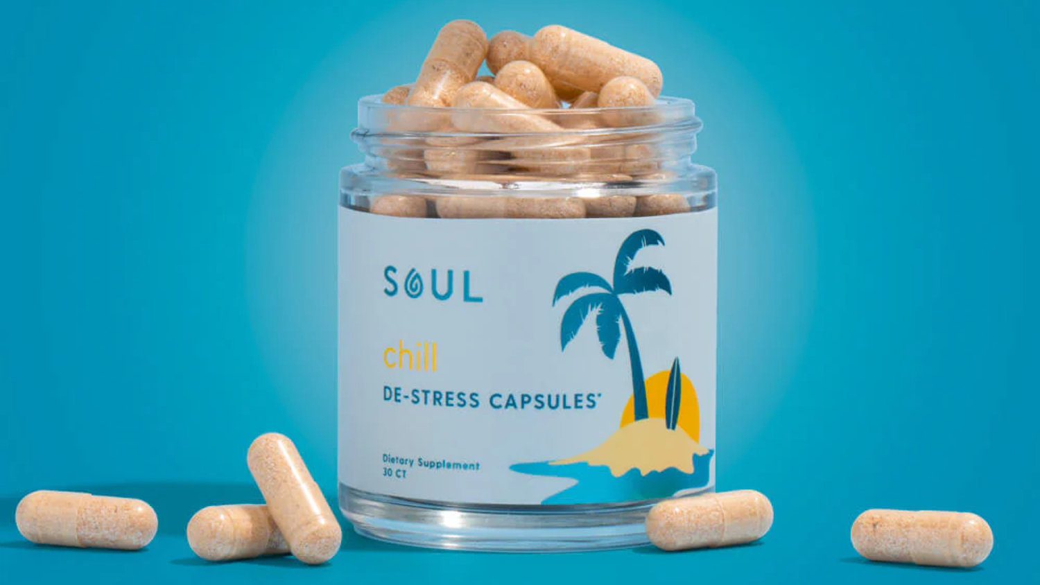Front view of Soul Chill De-Stress Capsules jar showing label with palm-tree graphic and loose beige capsules on teal background