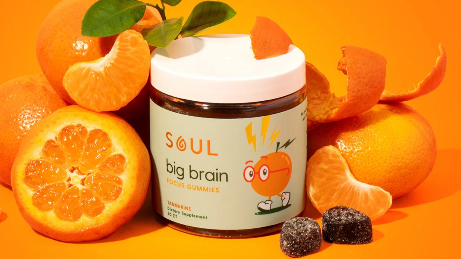 Front view of Soul Big Brain Focus Gummies jar showing label and two gummies with tangerine slices on orange background