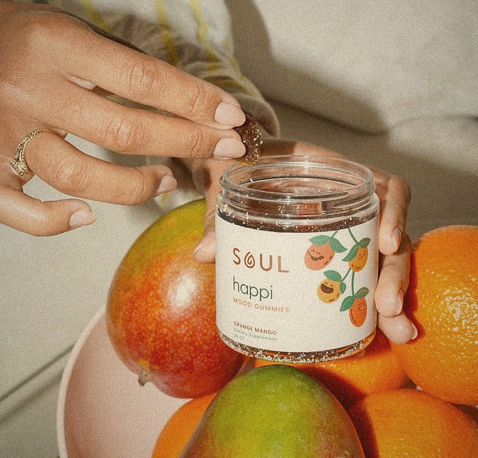 Hand holding a jar of Soul Happi mood gummies