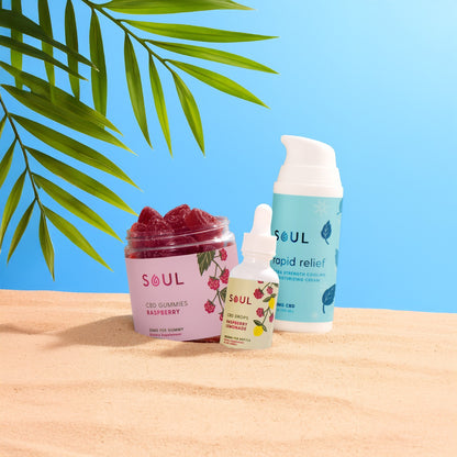 Front view of Healthline Select Bundle showcasing SOUL raspberry gummies jar, CBD dropper, and Rapid Relief pump on sandy beach